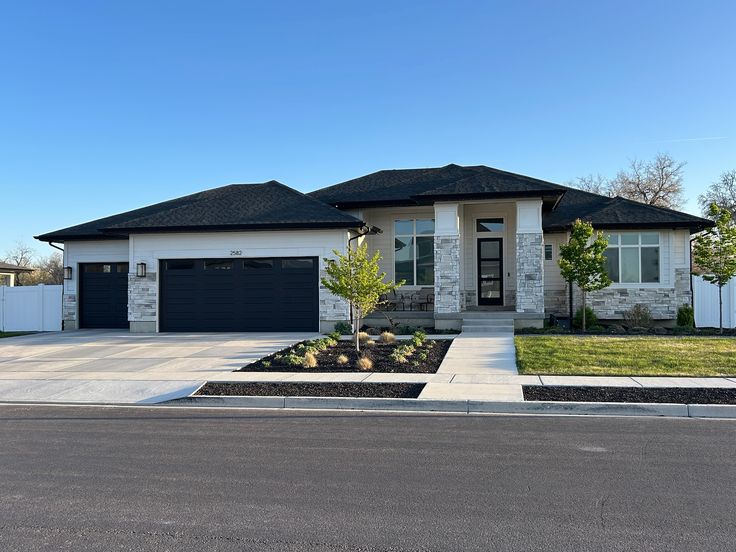 Modern single-story Texas home with black trim, stone accents and a wide driveway