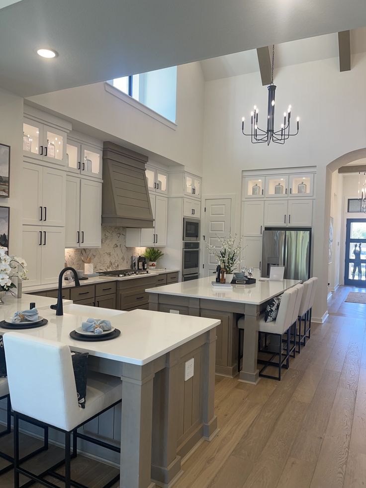 Open Texas kitchen with double quartz islands, white cabinetry and a vaulted ceiling